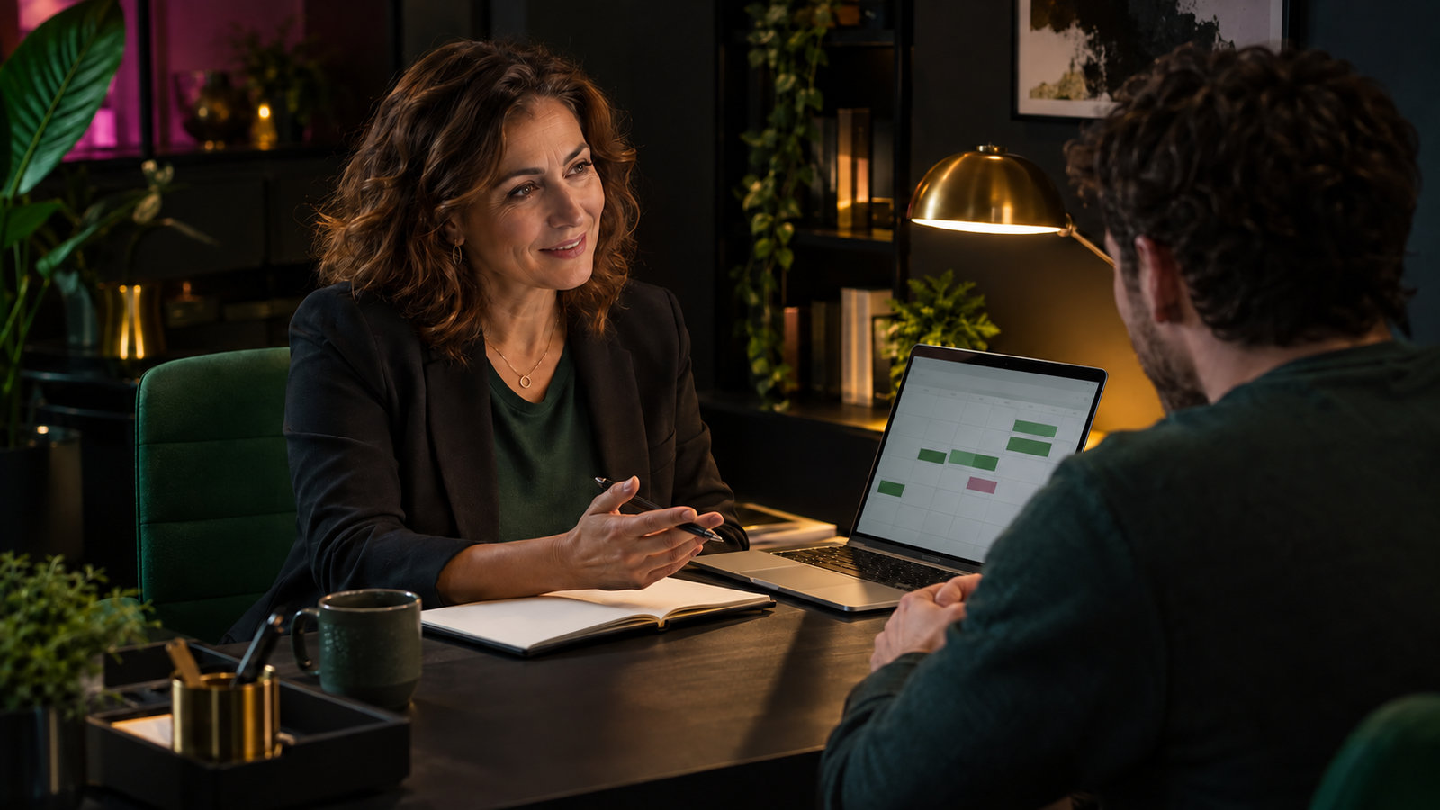 HR-Managerin bespricht mit einem Mitarbeiter die Urlaubsplanung am Laptop